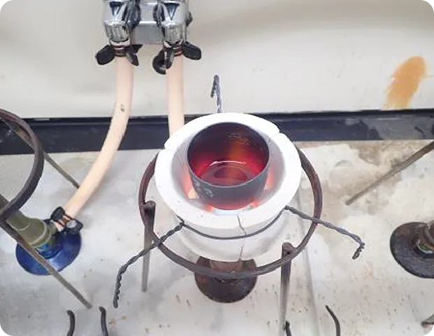 三脚台の上で加熱されている金属容器