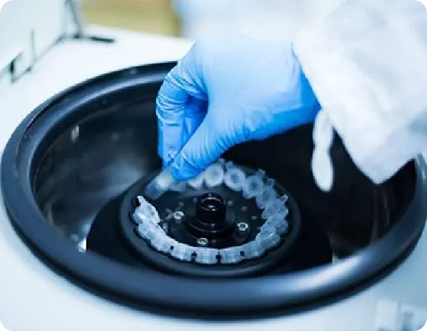 実験装置に設置された試験管を操作する手。