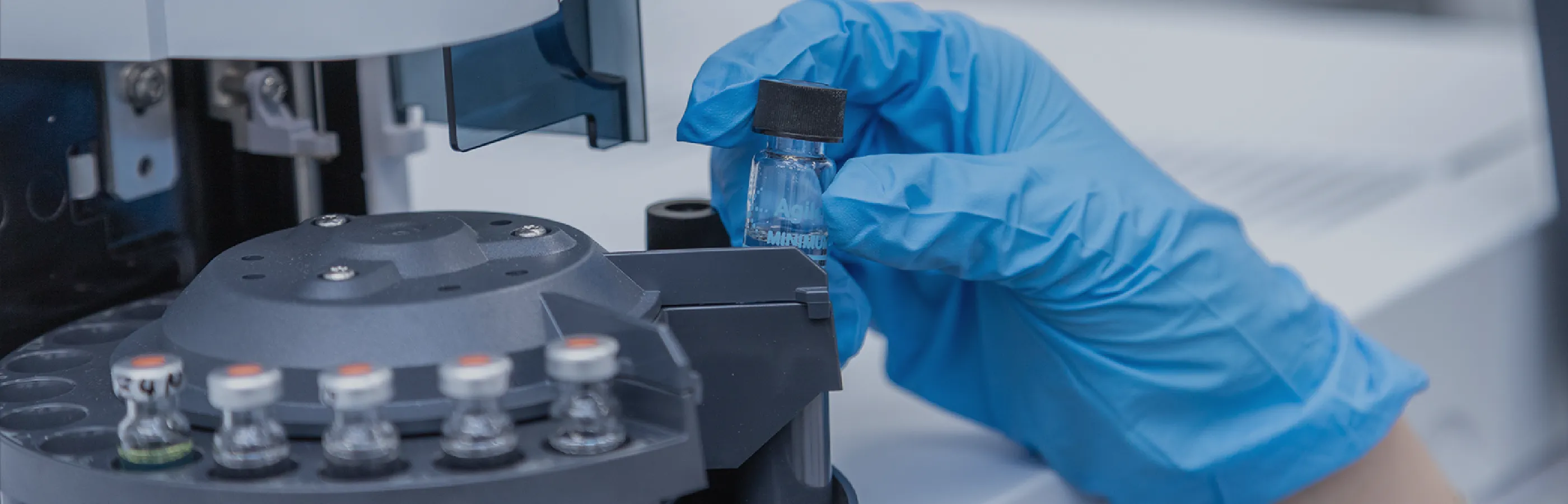 作業着を着た人が試験管を持っている