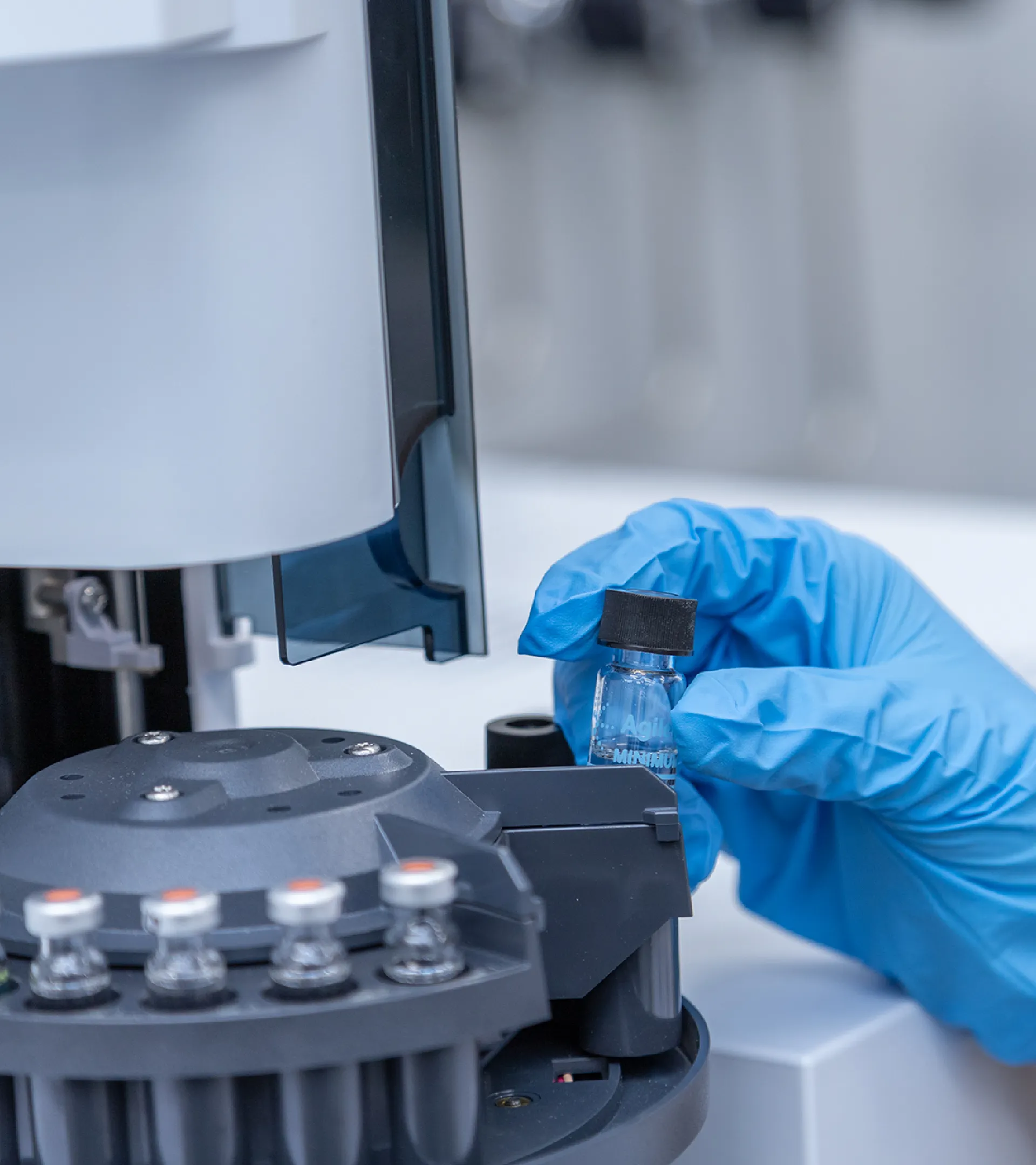 作業着を着た人が試験管を持っている