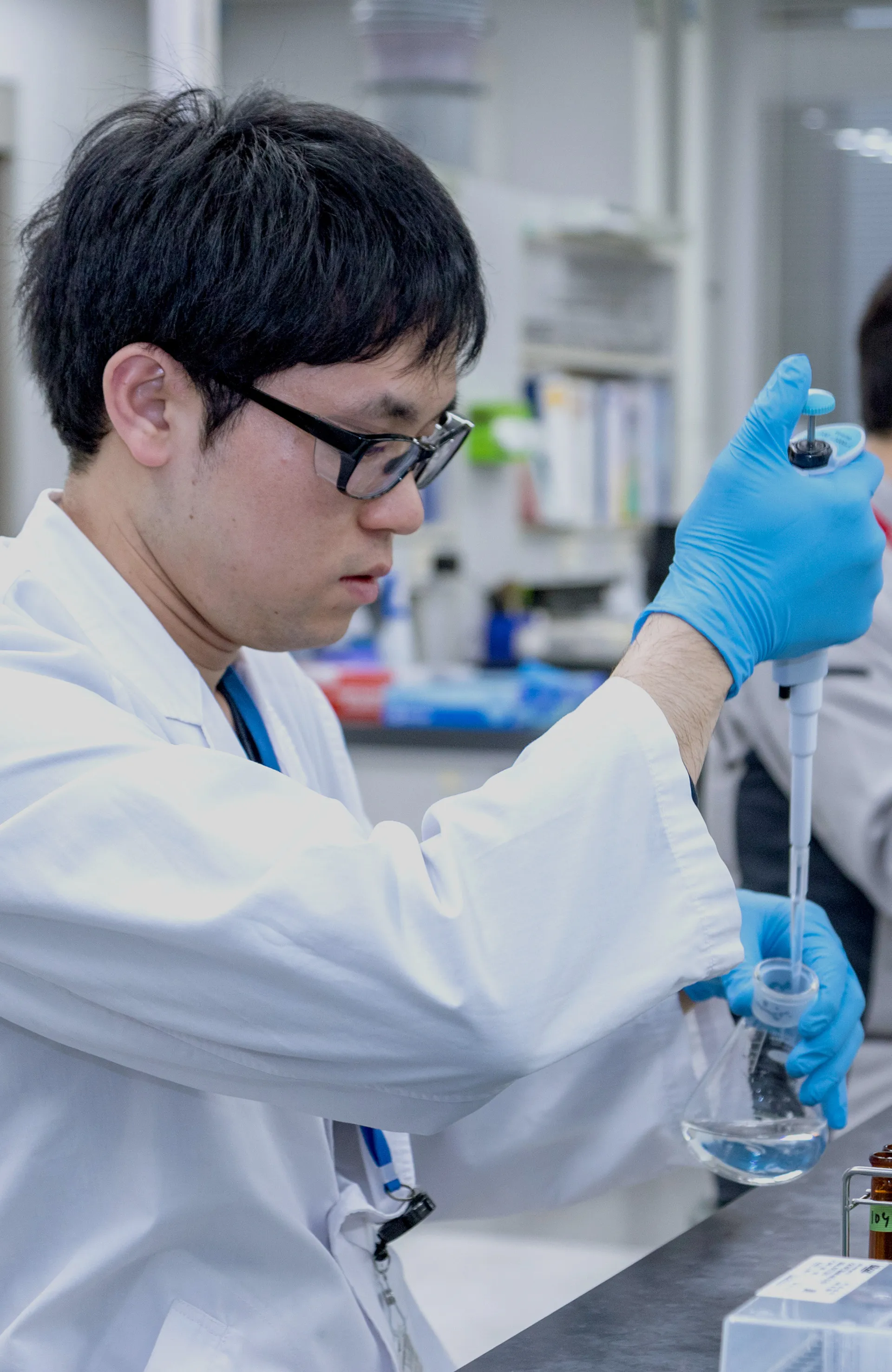 研究者ががスポイトで液体を調査する様子