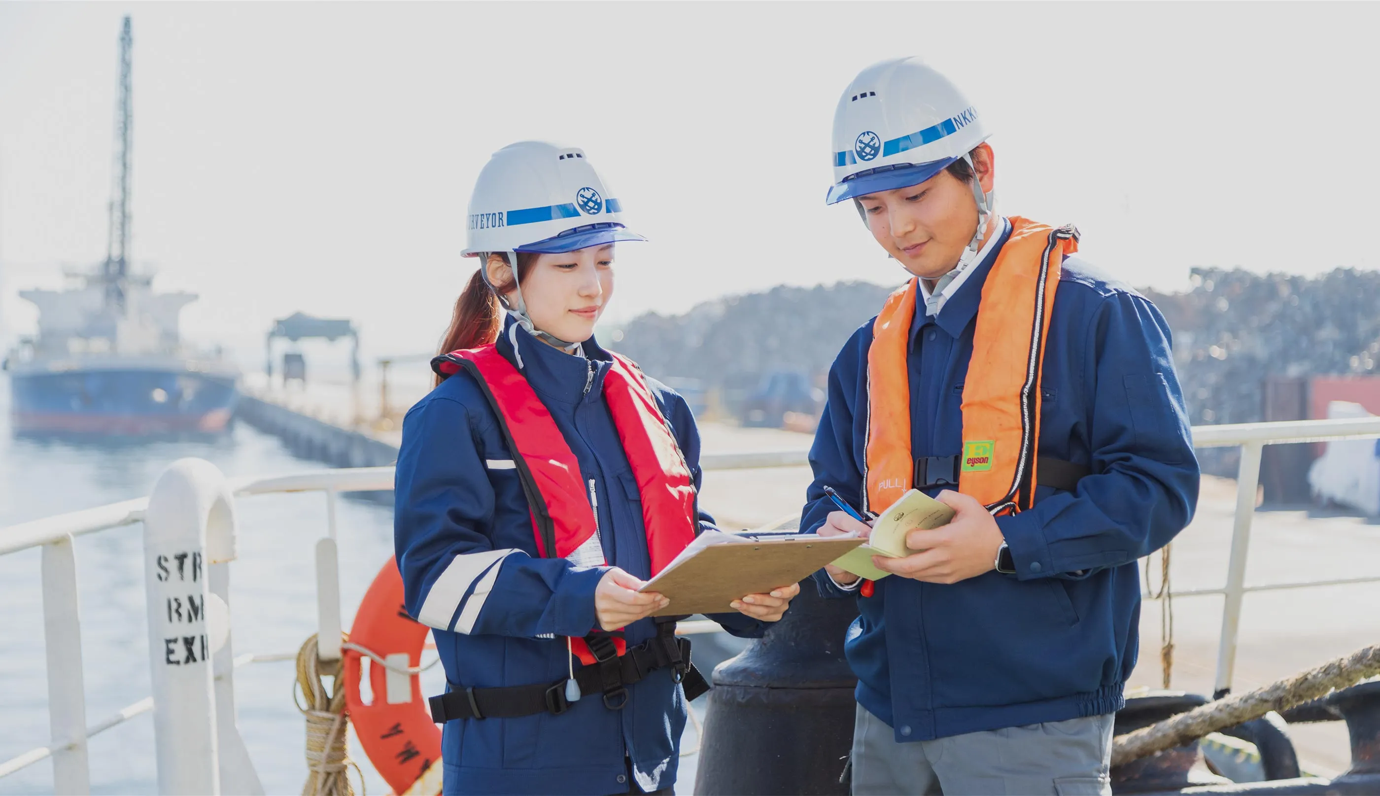 男女2人がバインダーを眺めて相談する様子