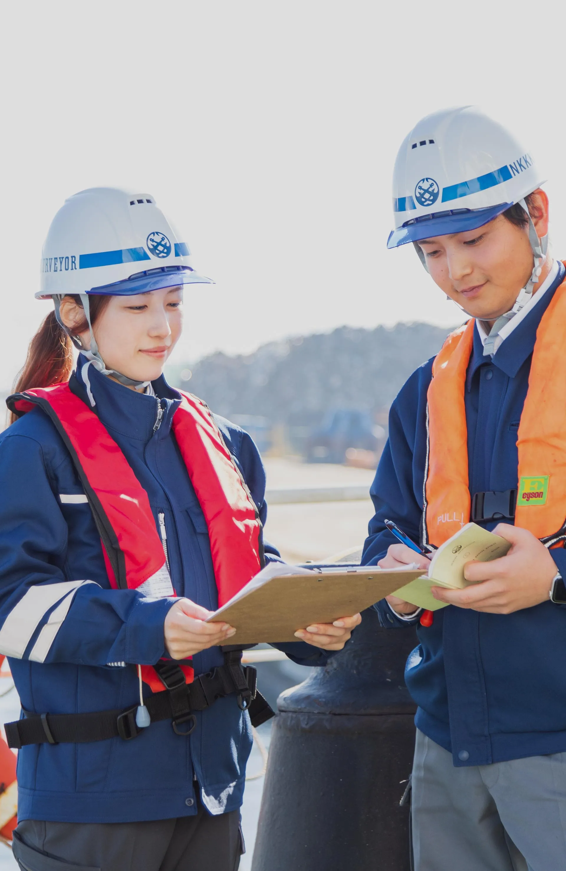 男女2人がバインダーを眺めて相談する様子