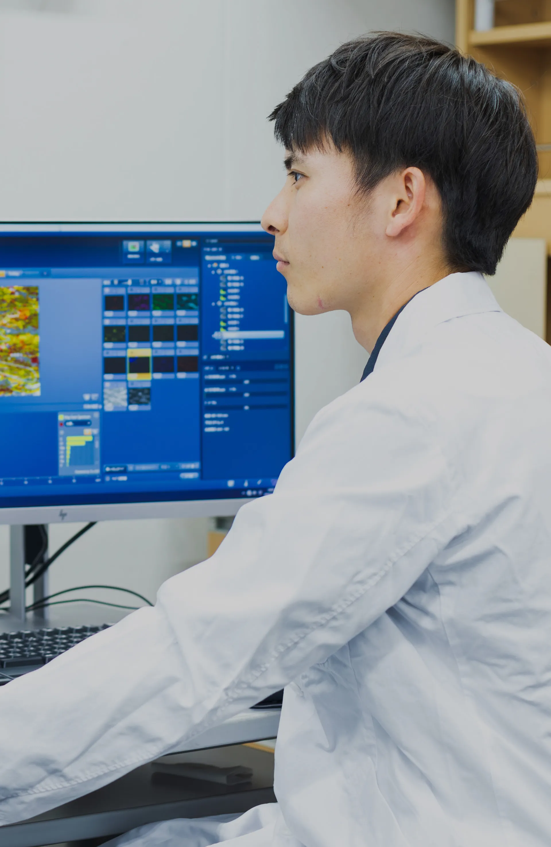 研究者がPCで微細なものを確認する様子